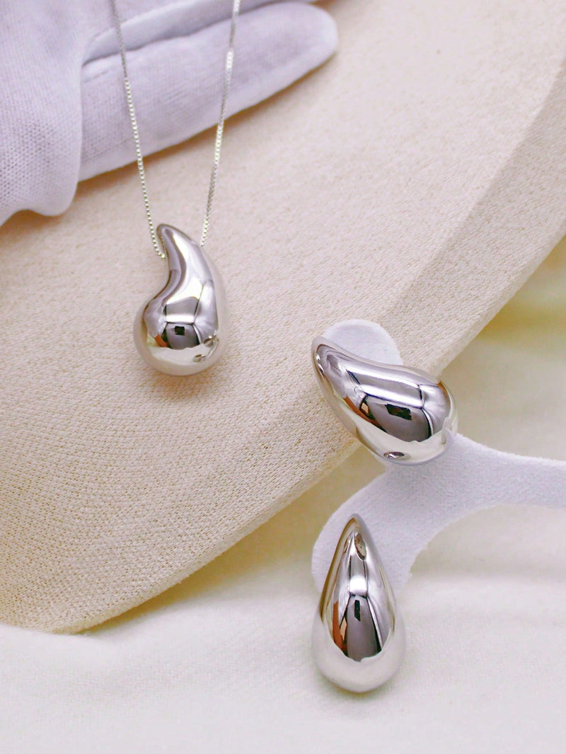 Acessórios: Colar e brincos com formato de gotas.